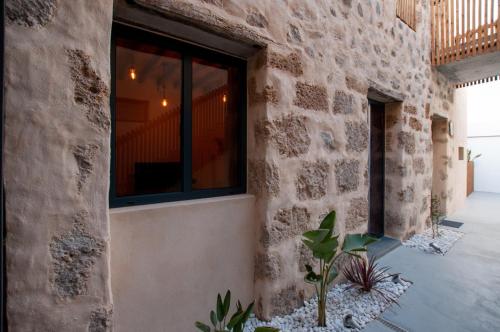 a stone building with a window and a potted plant at La Casa de San Juan - BENTEJUI in Telde