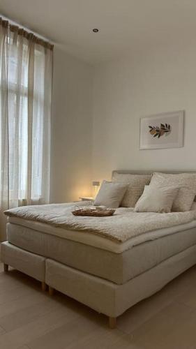 1 dormitorio blanco con 1 cama grande frente a una ventana en Stilvolle Luxus City-Apartment en Viersen