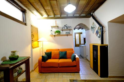 - un salon avec un canapé orange dans l'établissement Casetta privata nel corso, à Pitigliano