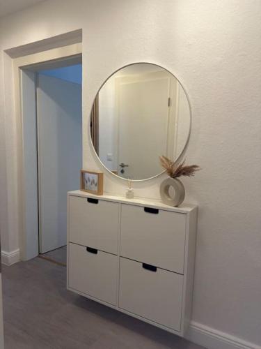 a white dresser with a mirror on top of it at Stilvolle Luxus City-Apartment in Viersen