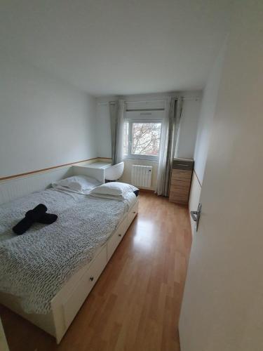 une chambre avec un lit avec un chapeau dessus dans l'établissement F3 avec balcon 5 min gare SQY et Parking gratuit, à Guyancourt