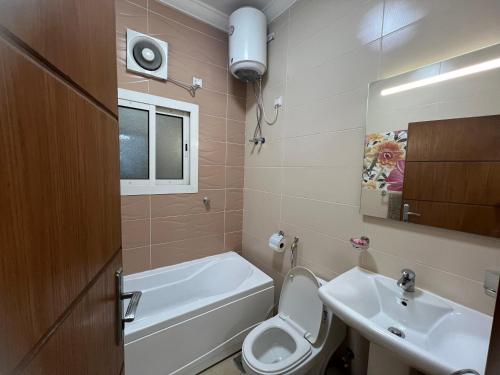 uma casa de banho com um WC, um lavatório e uma banheira em MAKKAH AL RUSAIFAH Apartment em Meca