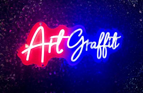 a neon sign that says air sparkle on a purple background at Art Graffiti in Miami