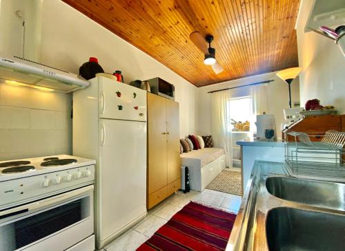 uma cozinha com um lavatório e um frigorífico branco em Camarina Sea View em Kamarína