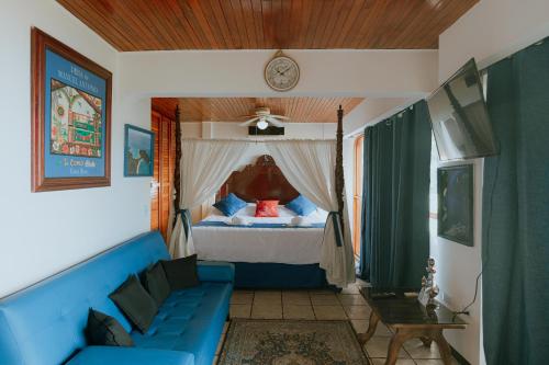 a living room with a blue couch and a bed at Manuel Antonio Inn Paradise in Quepos