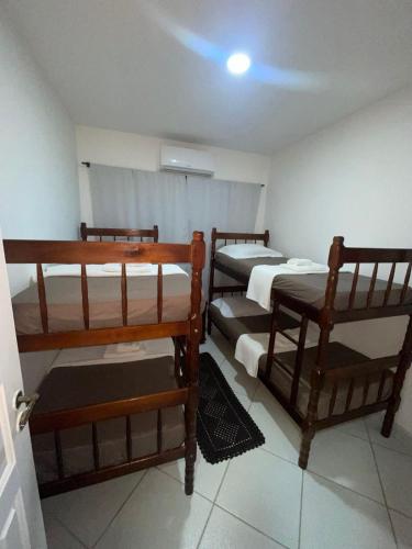 a room with three bunk beds in a room at Francisco's House in Angra dos Reis