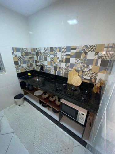 a kitchen with a counter top with a microwave at Francisco's House in Angra dos Reis