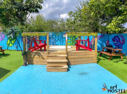 a playground with a swing set on a blue ground at Art Graffiti in Miami