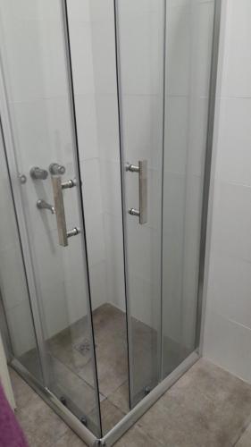 a shower with glass doors in a bathroom at Amarello in Gualeguaychú