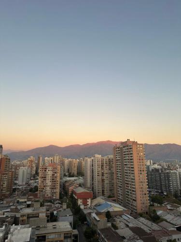 een stad met hoge gebouwen en bergen op de achtergrond bij Dpto 2D 1B, Parque Almagro, Santiago. in Santiago