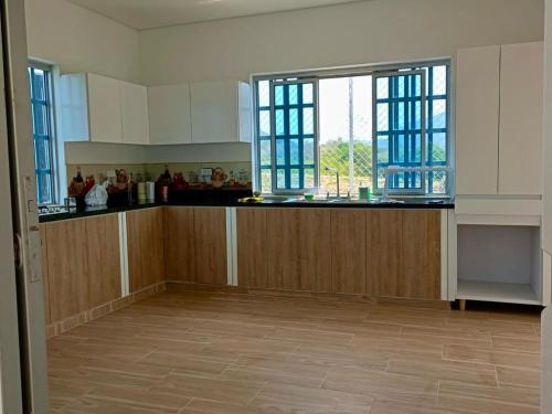a kitchen with wooden cabinets and a large window at Finca Villa Elenita in Jericó