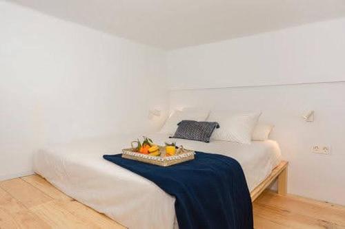 a white bed with a tray of fruit on it at CASA ALTA LOFT in Málaga
