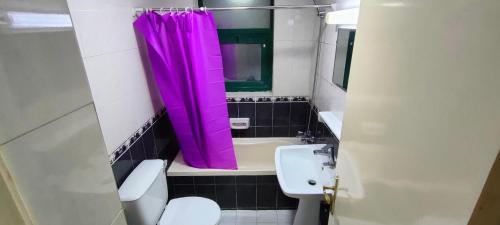 ein Badezimmer mit einem rosa Duschvorhang und einem Waschbecken in der Unterkunft Cozy Bedroom for Gent in Schardscha