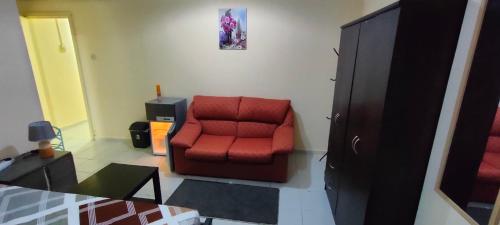 a red chair sitting in a living room at Cozy Bedroom for Gent in Sharjah