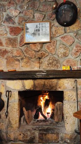 a stone fireplace with a fire in it at Bodega típica en El Molar sin camas ni dormitorios in El Molar