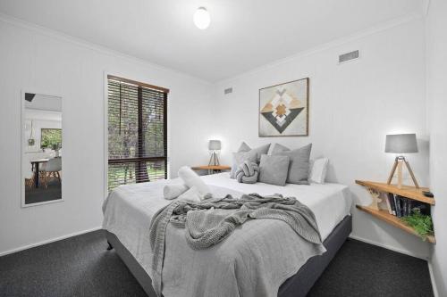 a white bedroom with a large bed and a window at Algona Views in Halls Gap