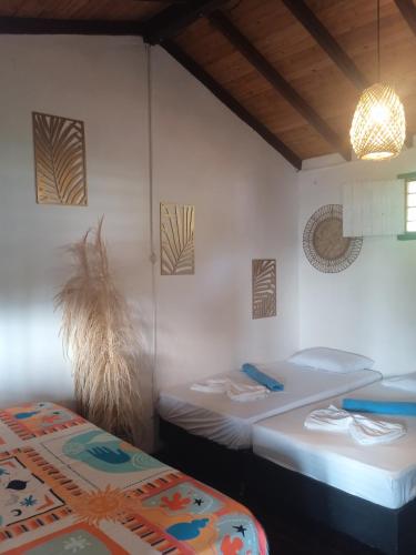 a room with two twin beds and a light fixture at Casa Yemaya in Necoclí