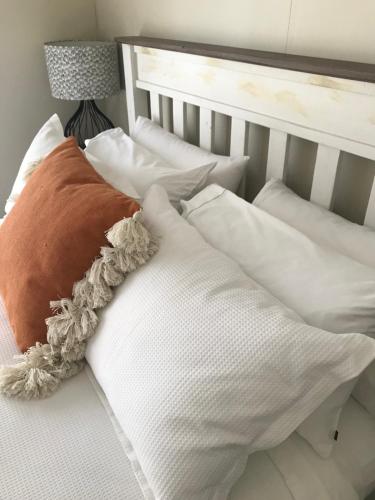 Cama blanca con almohadas blancas y lámpara en Robyn's Nest en Sentry Hill