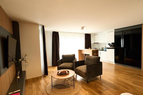 a living room with two chairs and a table at Cartea Apartments Zürich Airport in Opfikon
