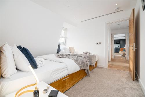 a white bedroom with a bed and a desk at Marble Arch Penthouse 1 Bed in London