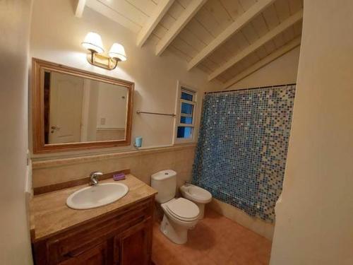 a bathroom with a sink and a toilet and a mirror at Casa equipada para 8 personas a tres cuadras del mar - Colibrí 1 in Mar Azul