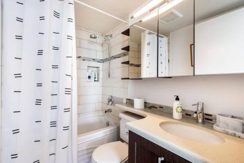 uma casa de banho com um lavatório, um WC e uma banheira em Luxury 2-bedroom condo beach side Yaletown em Vancouver
