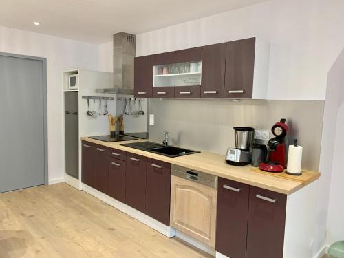 une cuisine avec des armoires marron et un comptoir dans l'établissement Etxatzia, à Larrau