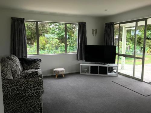 a living room with a flat screen tv and a couch at Ocean Air Carters Beach in Carters Beach