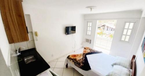 Kleines Zimmer mit einem Bett und einem Fenster in der Unterkunft Suíte Privativa com Varanda Ar Cond TV Wi-Fi 201 in Cabo Frio