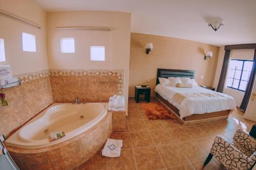 a bedroom with a bed and a tub in a room at Hotel Real de San Jose in Tequisquiapan