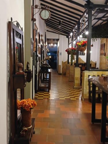 San Vicente de Chucurí的住宿－Hotel Boutique Casa Antigua，带有桌子和鲜花的餐厅走廊