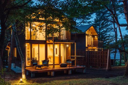 a tiny house sits on a wooden deck at night at PICA Yamanakako Village in Yamanakako