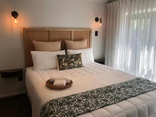 a bedroom with a large bed with a basket on it at Vista - touch of country and spa in Havelock North