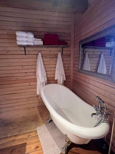 baño con bañera en una pared de madera en Chalet Le Verdier, en Champlain