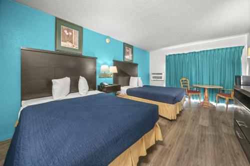 a hotel room with two beds and a table at Executive Inn in Rusk