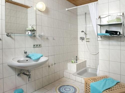 een witte badkamer met een wastafel en een douche bij Inviting apartment in Partschins Rabland in Enkirch