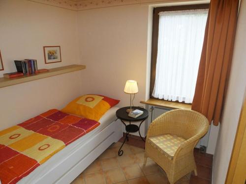 een kleine slaapkamer met een bed en een stoel bij Inviting apartment in Partschins Rabland in Enkirch
