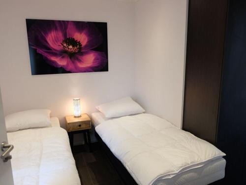 twee bedden in een kamer met een bloem op de muur bij Holiday home with motorboat in Olburgen