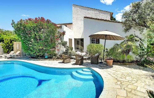 a house with a swimming pool and an umbrella at La Maison De Nelly in Paradou