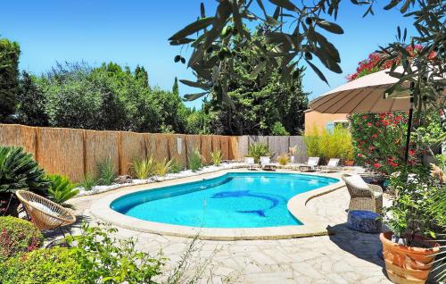 - une piscine dans un jardin avec un parasol dans l'établissement La Maison De Nelly, à Paradou