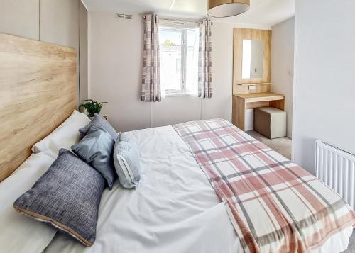 a bedroom with a large white bed with blue pillows at Towervans Caravan Park in Mablethorpe