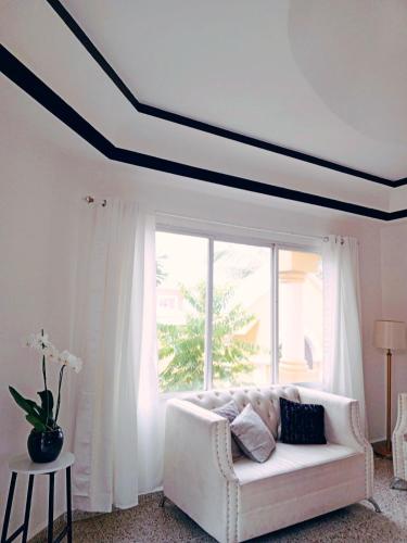 Habitación con balcón en una Mansión في تيغوسيغالبا: غرفة معيشة مع أريكة بيضاء ونافذة