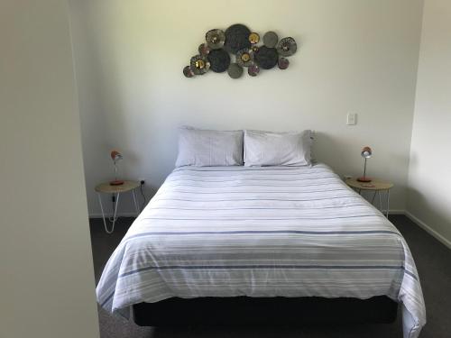 a bedroom with a large bed with two tables at Ocean Air Carters Beach in Carters Beach