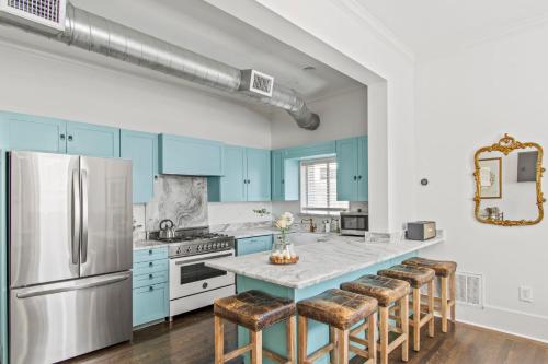 a kitchen with blue cabinets and a island with bar stools at HUGE outdoor patio with Pool and BBQ - Sleeps 19 in Austin