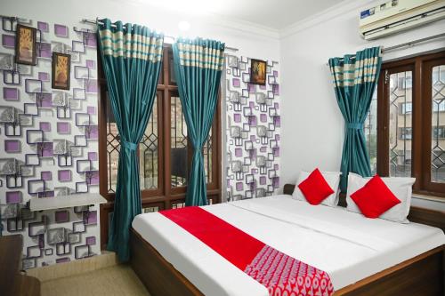 - une chambre dotée d'un lit avec des oreillers verts et rouges dans l'établissement OYO Flagship Shraddha Residency 2, à Kolkata