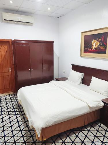 a bedroom with a large bed with white sheets at منتجع الريحانه فلة رقم ٢ in Al Wahţ