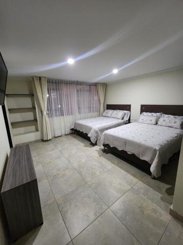 a bedroom with two beds and a television in it at HOTEL CASA MARED Corferias-Embajada Americana in Bogotá