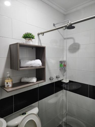 a bathroom with a toilet and a glass shower at HOTEL CASA MARED Corferias-Embajada Americana in Bogotá