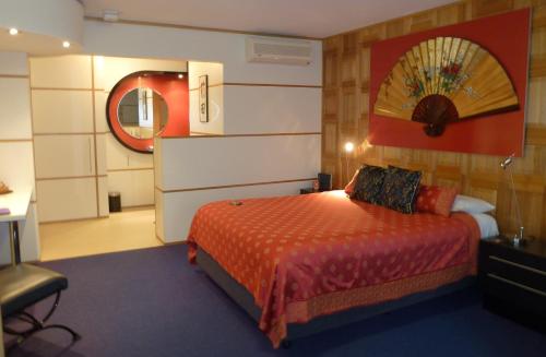 um quarto de hotel com uma cama e um espelho em The Retreat at Froog Moore Park em Tamworth