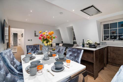 a living room with a table with a vase of flowers at Marble Arch Penthouse 2 Bed in London